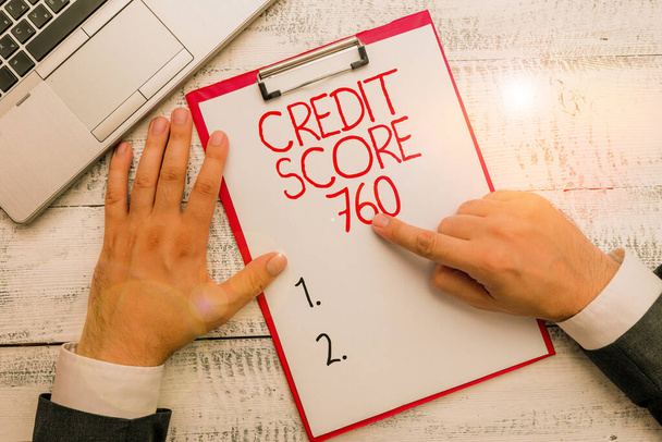 Text sign showing Credit Score 760. Conceptual photo numerical expression based on level analysis of demonstrating Hand hold writing equipment tool near modern high technology laptop device. - Foto, Imagem