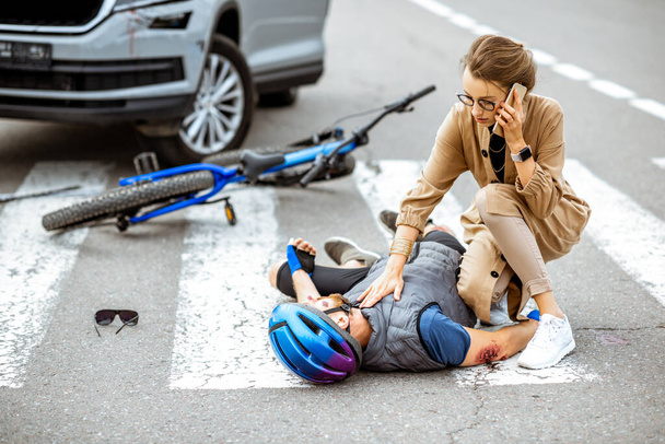 Road accident with injured cyclist and car driver - Fotografie, Obrázek