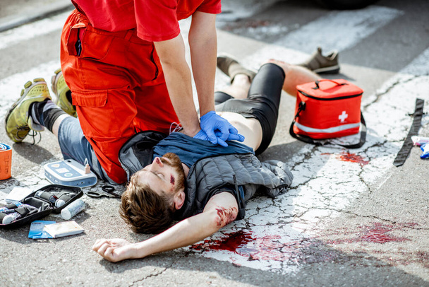 Medico che applica cure di emergenza dopo l'incidente stradale
 - Foto, immagini