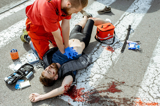 Médecin appliquant les soins d'urgence après l'accident de la route
 - Photo, image