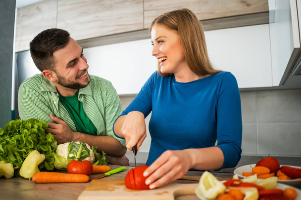 Young couple is preparing meal in their kitchen. - Foto, Bild