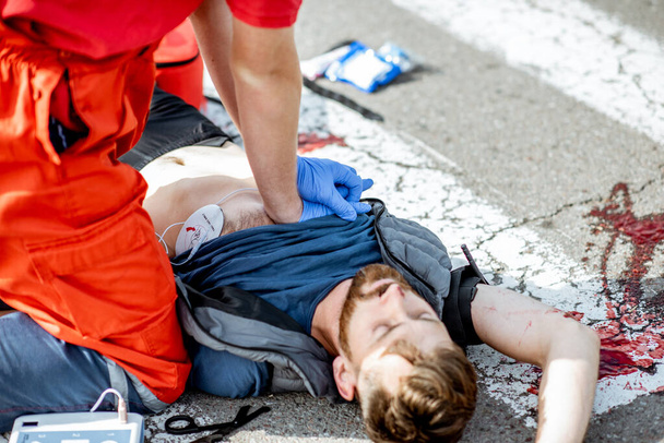 Médecin appliquant les soins d'urgence après l'accident de la route
 - Photo, image