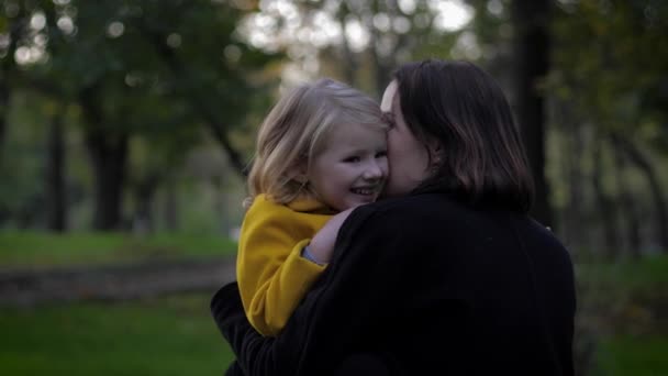 tiempo feliz, madre sensible juega cuidadosamente con su encantadora hija en el prado en el parque de otoño durante las vacaciones familiares
 - Metraje, vídeo
