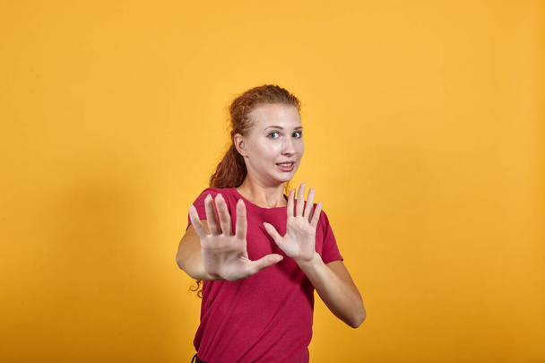 Mujer joven decepcionado en camisa roja haciendo parada ningún gesto
. - Foto, Imagen