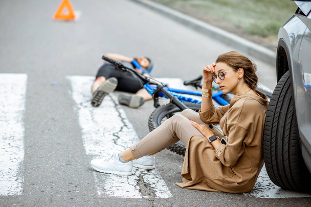 Trafik kazasından sonra üzgün kadın sürücü ve yaralı adam - Fotoğraf, Görsel