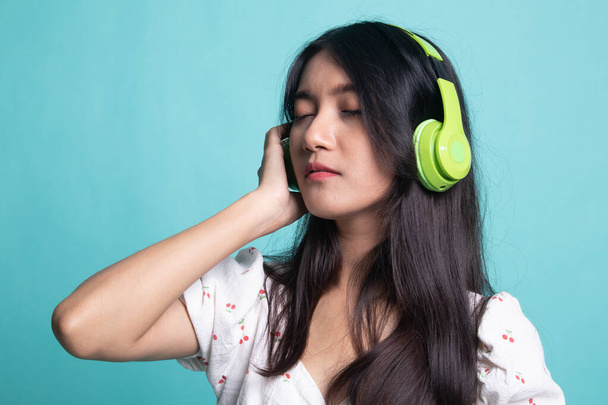 Pretty asian girl listening music with her headphones. - 写真・画像