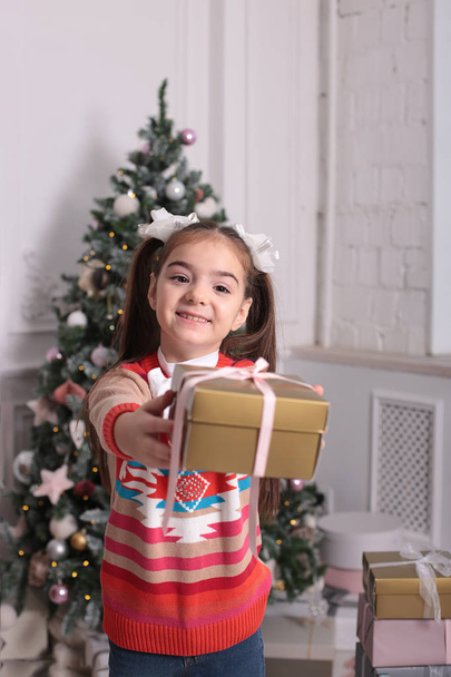 遊び心のある雰囲気の中で長いブロンドの髪を持つ美しい女の子のクリスマスの肖像画は異なる感情を示しています - 写真・画像