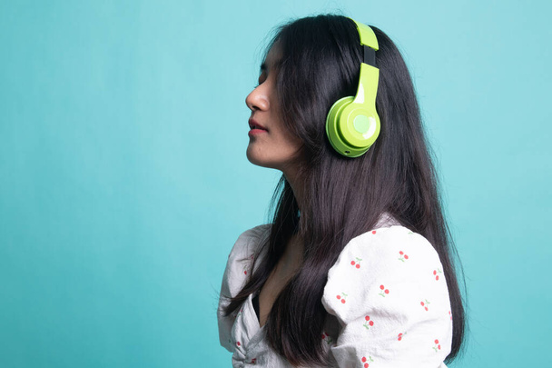 Pretty asian girl listening music with her headphones. - Valokuva, kuva