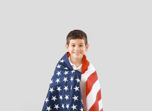 Little boy with USA flag on light background. Memorial Day celebration - Foto, Imagem