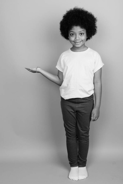 Mladý roztomilý africký dívka s afro vlasy v černé a bílé - Fotografie, Obrázek