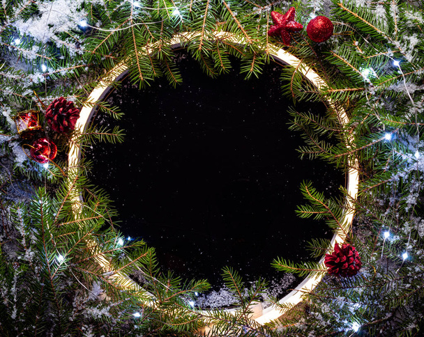Christmas round frame made by neon and winter things on black background. - Фото, изображение
