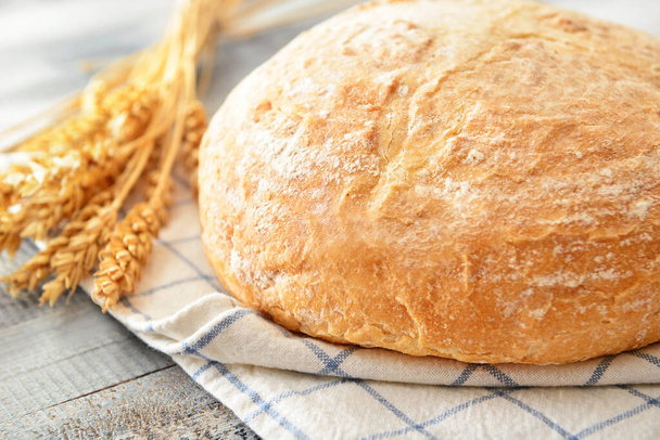 Fresh bread with spikelets on table - Foto, Bild