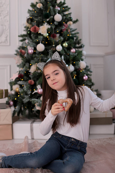 Christmas portrait of a beautiful girl with long blond hair in a playful mood depicts different emotions - Photo, Image