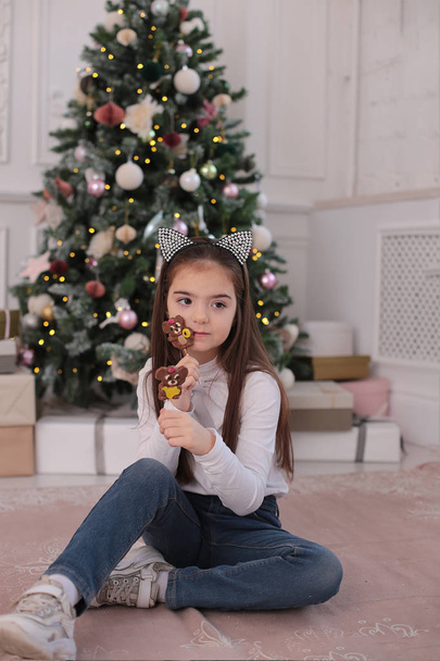 Retrato de Navidad de una hermosa chica con el pelo largo y rubio en un estado de ánimo juguetón representa diferentes emociones
 - Foto, Imagen