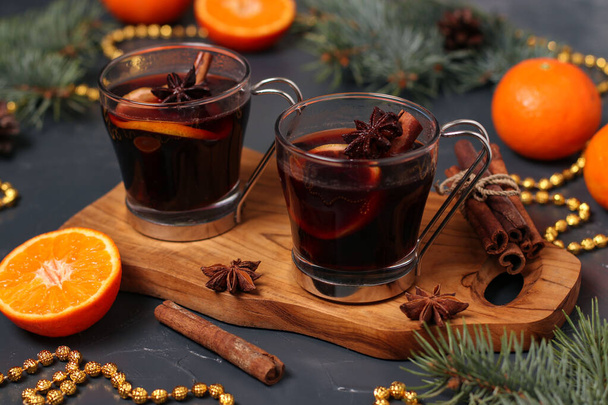 Vánoční svařené víno a mandarinky na tmavém pozadí, detailní záběr, horizontální orientace - Fotografie, Obrázek