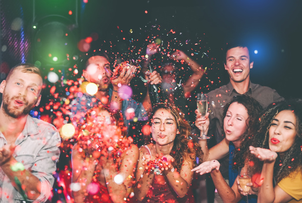 Счастливые друзья, бросающие конфеты в ночном клубе - Группа молодых людей, весело празднующих Новый год вместе в дискоклубе - Молодежная культура развлекательная концепция образа жизни
 - Фото, изображение