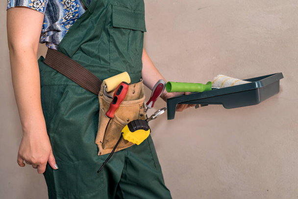 Koruyucu üniformalı kadın resim aletlerini gösteriyor - Fotoğraf, Görsel