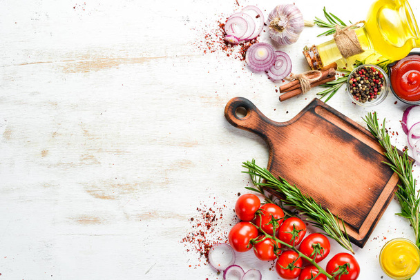 White wooden background of cooking. Spices and vegetables. Top view. Free space for your text. - Φωτογραφία, εικόνα