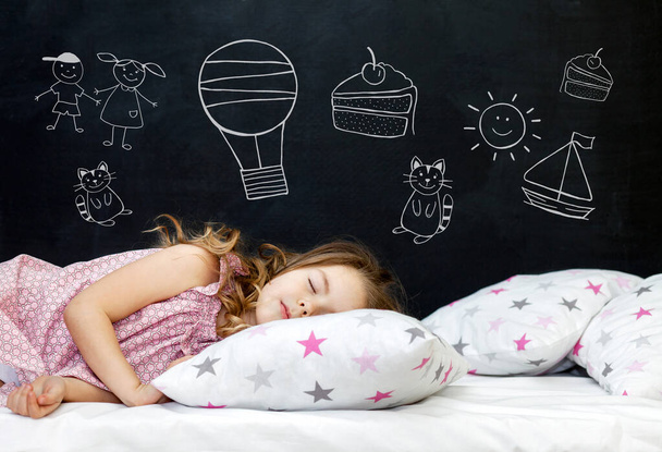Charming little girl of preschool age sleeps in bed on a pillow with stars. Time to sleep. Drawing about the dreams of a child: kitten, dessert, adventure and friendship. - Foto, Imagen
