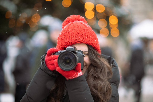 冬に屋外でプロのカメラ撮影をする女性写真家 - 写真・画像