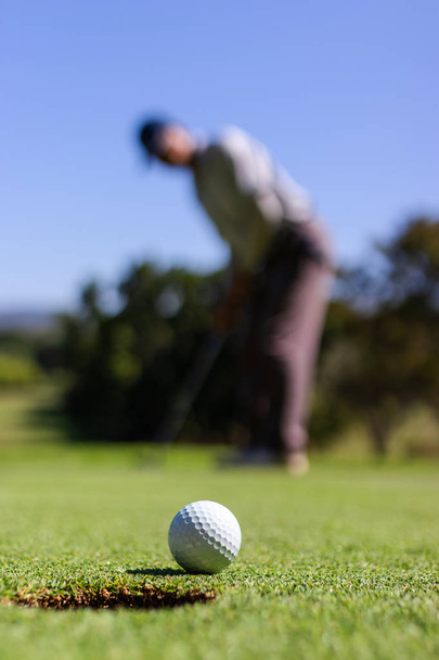 Golfista mettendo pallina da golf in buco
 - Foto, immagini