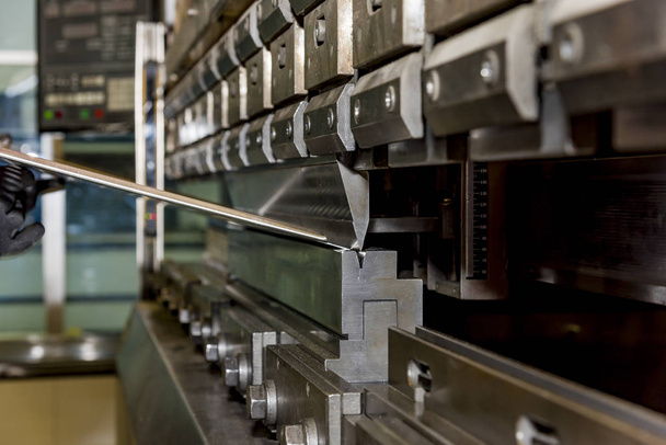 worker operating metal press machine at workshop. - Photo, Image