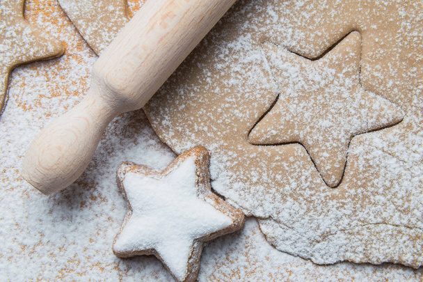 Dough with other Christmas baking ingredients on the table. Star shape cookies preparation. - Foto, afbeelding