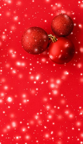 Christbaumkugeln auf rotem Hintergrund mit Schneeglitzern, Luxus - Foto, Bild