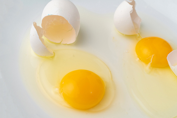 Tabakta yemek hazırlamak için kırılmış beyaz bir yumurta. - Fotoğraf, Görsel