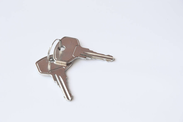Grey metal keys on white background. Keys for the door lock. Two keys to the front door. - Foto, imagen