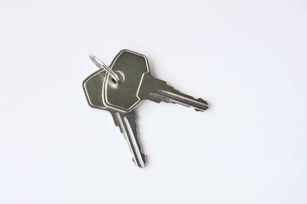 Grey metal keys on white background. Keys for the door lock. Two keys to the front door. - Foto, imagen