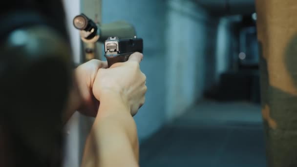 Chica toma puntería sosteniendo un arma en sus manos
 - Metraje, vídeo