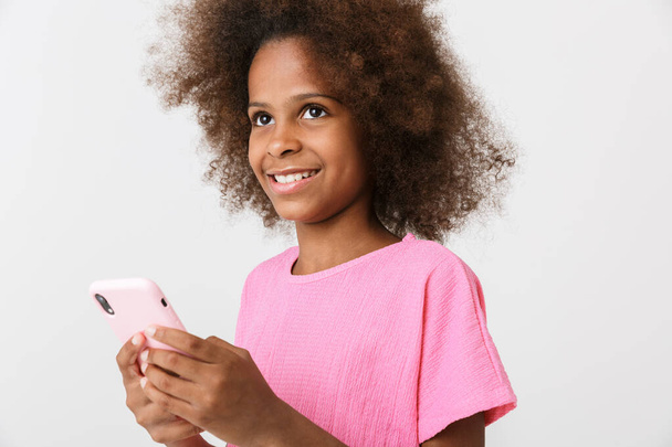 Cheerful little african girl wearing pink blouse standing - Foto, imagen