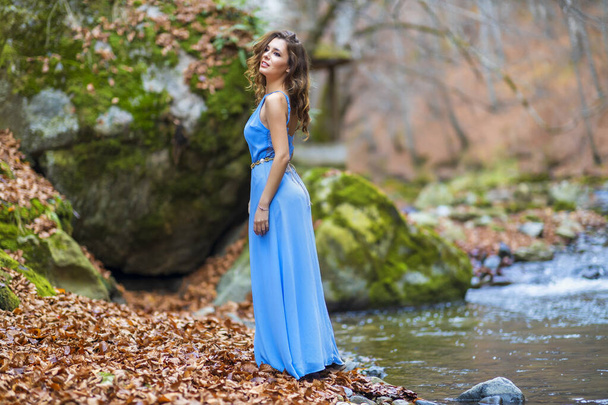 woman in blue dress near a river in autumn day - Photo, Image