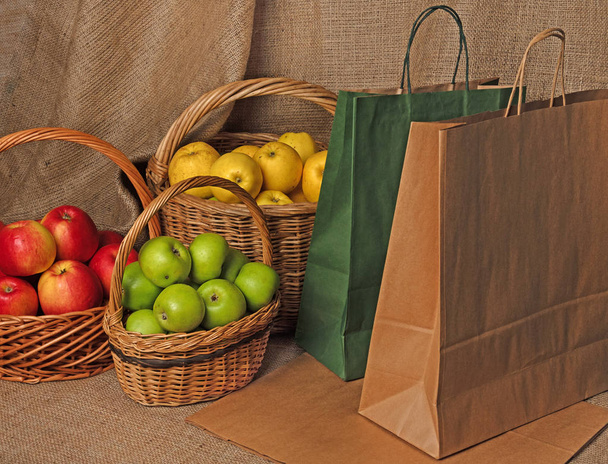 alma kosárban és papírzacskós kézműves csomagolásban, alma szüret utáni válogatására - Fotó, kép