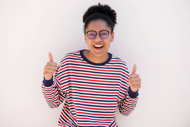 Portrait of happy young african american girl with glasses and thumbs up hand sign - Foto, afbeelding