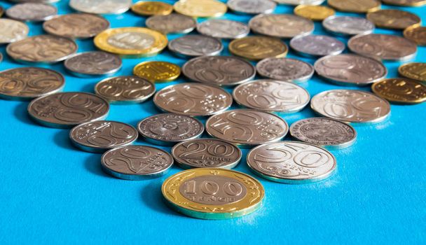 Tenge auf blauem Hintergrund mit Münzen. Tenge-Münzen in Kasachstan - Foto, Bild