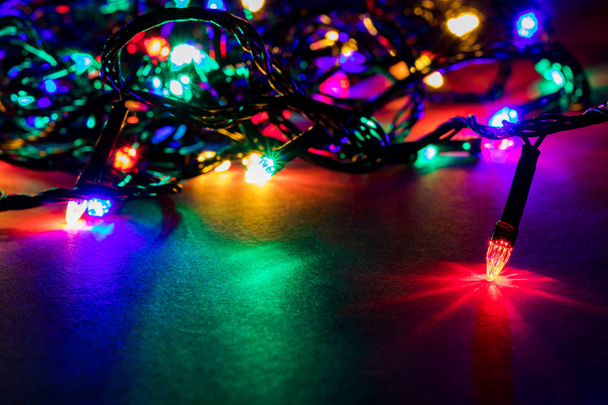 Kerst slinger lichten op donkere achtergrond - Foto, afbeelding