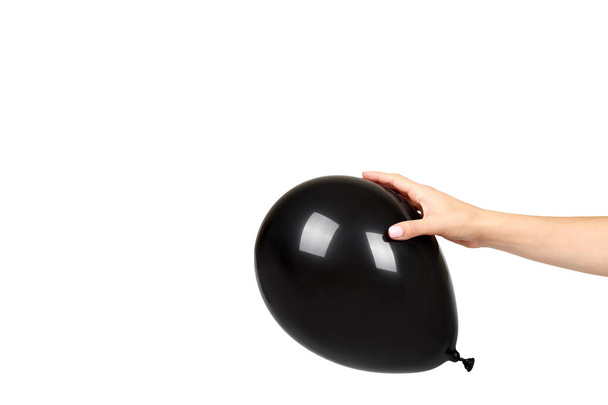 Χέρι με μαύρο φουσκωτό μπαλόνι, διακόσμηση πάρτι κόμμα, γυαλιστερό μπάλα. - Φωτογραφία, εικόνα