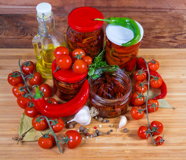Αποξηραμένες ντομάτες σε λάδι, διατηρημένο τσίλι σε γυάλινα βάζα, συστατικό - Φωτογραφία, εικόνα