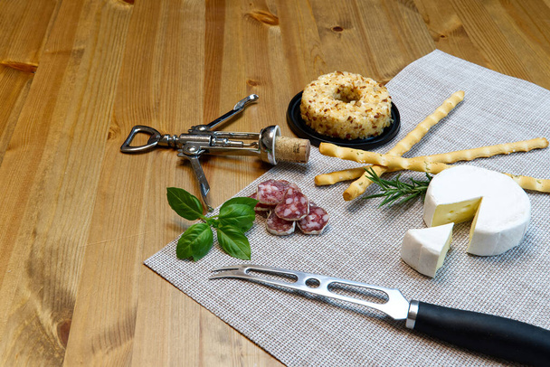 Selección de aperitivo de queso o mesa de fiesta de queso y vino. Queso brie, palitos de pan y salami es un gran aperitivo para comenzar su cena
. - Foto, imagen