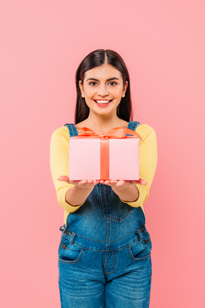 glücklich schwangeres hübsches Mädchen hält Geschenkbox isoliert auf rosa - Foto, Bild