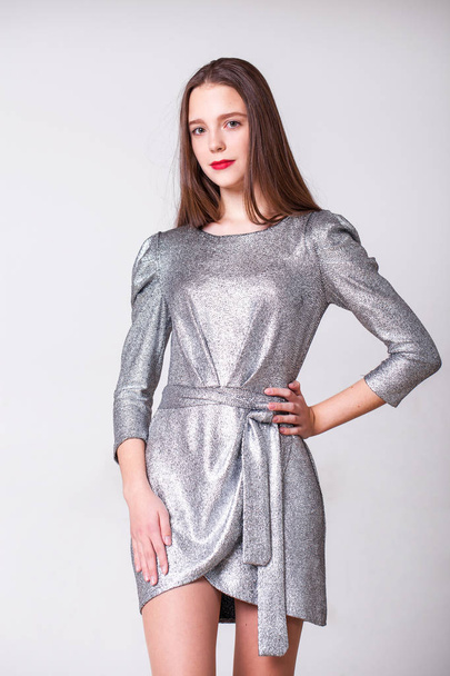Young beautiful model with a silver stylish dress  - 写真・画像