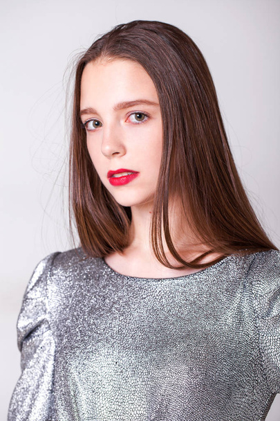 Young beautiful model with a silver stylish dress  - 写真・画像