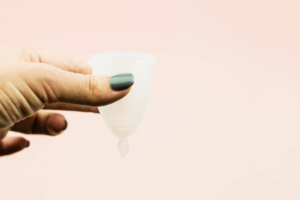close-up van de vrouw hand houden menstruele cup in katoenen zak - Foto, afbeelding