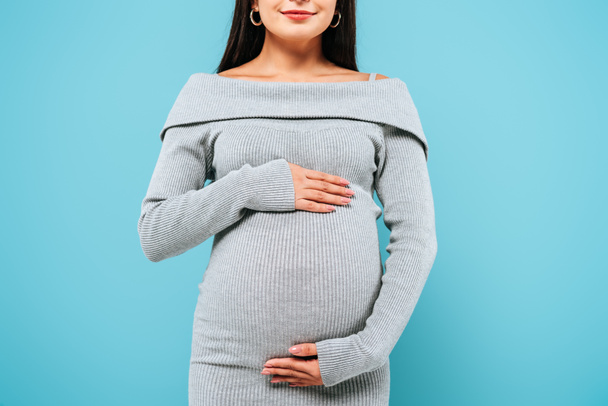 cropped view of smiling pregnant pretty girl touching belly isolated on blue - Φωτογραφία, εικόνα