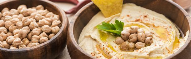 delicious hummus with chickpeas and nacho in bowls, panoramic shot - Фото, изображение