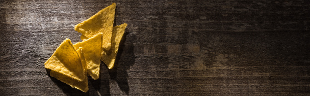 вид на вкусные хрустящие кукурузные начос на деревянном деревенском столе, панорамный снимок
 - Фото, изображение