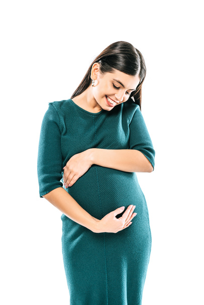 smiling pregnant girl touching belly isolated on white - Fotó, kép
