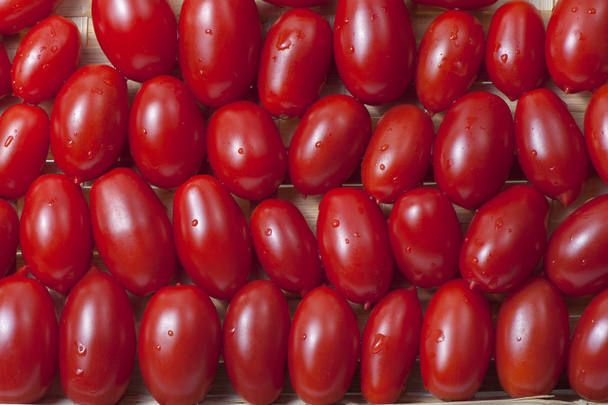 Pequeños tomates rojos maduros oblongos
 - Foto, Imagen